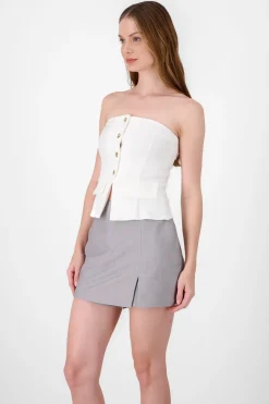 Top formal con bolsas y accentos de botones